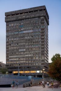 un edificio alto con gente parada frente a él en Cristina Enea Rooms, en San Sebastián