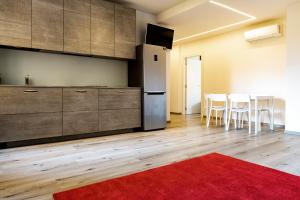 Una cocina con refrigerador y una mesa con sillas. en Roma Ariston 7, en Bolzano