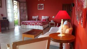 a living room with a bed and a red wall at Villa Thomas bouillante in Bouillante