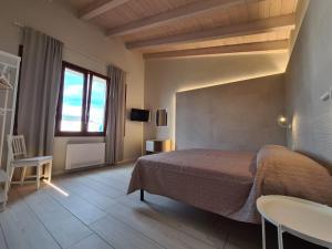 a bedroom with a bed and a table and a window at B&B Locanda de' Colli in Signa