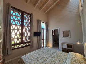 a bedroom with a bed and a large window at B&B Locanda de' Colli in Signa