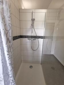La salle de bains est pourvue d'une douche avec rideau de douche. dans l'établissement 6 personnes, neuf & cosy, centre - gare, à Mulhouse