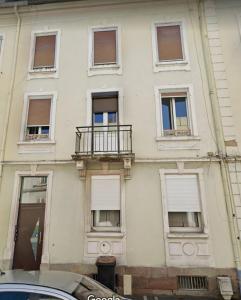 - un bâtiment blanc avec des fenêtres et un balcon dans l'établissement 6 personnes, neuf & cosy, centre - gare, à Mulhouse
