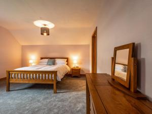 a bedroom with a bed and a mirror and a dresser at Granar in Derwen +77 photos