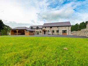 a stone house with a green lawn in front of it at Granar in Derwen