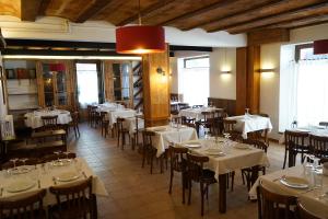 un restaurant avec tables et chaises et nappes blanches dans l'établissement Fonda Biayna, à Bellver de Cerdanya