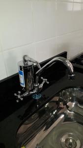 a bathroom sink with a faucet on a counter at Apto com armários e eletrodomésticos NOVOS in Cuiabá