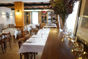 een restaurant met tafels en stoelen en een vaas met bloemen bij Fonda Biayna in Bellver de Cerdanya 