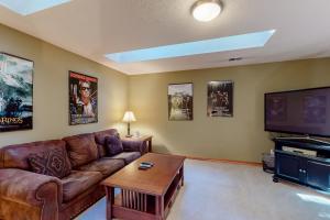 a living room with a couch and a flat screen tv at Welches Fairway Retreat in Welches