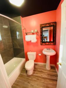a bathroom with red walls and a toilet and a sink at Casa Valentine Inn - Los Angeles in Los Angeles
