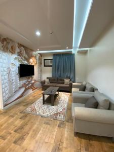 a living room with a couch and a tv at أزد للشقق المخدومة in Tanomah