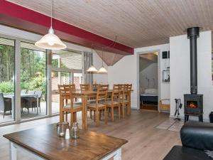 a dining room and living room with a table and a fireplace at 10 person holiday home in Henne in Henne Strand