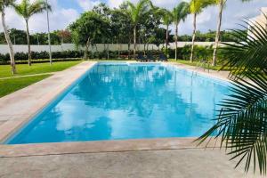 una piscina con agua azul y palmeras en El hogar que deseas para vacacionar!!!! en Cancún