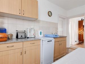 una cocina con armarios de madera y un aparato blanco en Cozy Apartment in Altenfeld with Garden, en Altenfeld