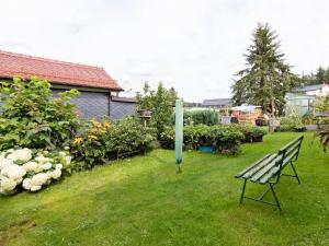 a park bench sitting in the grass in a yard at Cozy Apartment in Altenfeld with Garden in Altenfeld