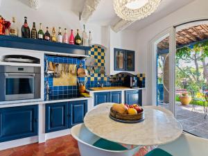 a kitchen with blue cabinets and a table with fruit on it at Scenic villa in Martigues with private pool in La Couronne