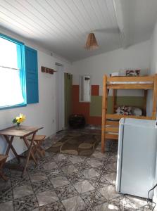 a room with a table and a refrigerator in it at Estação Caraíva in Caraíva