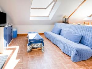 Sofá azul en la sala de estar con ventana en Magnificent flat with garden in Saint R my, en Clécy