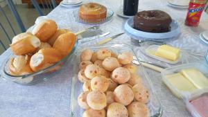 a table topped with trays of bread and pastries at Suítes Dona Paris in Capitólio