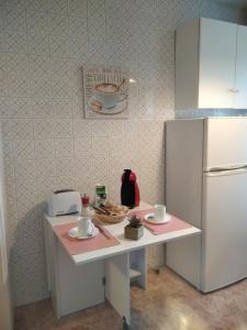 a kitchen with a white table with a refrigerator at Casa Amelia 1ªP a 50 m Camino de Santiago in Padrón