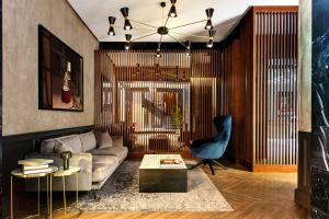 a living room with a couch and a chair at Radisson Blu Hotel, Madrid Prado in Madrid