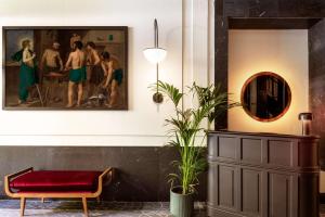 a living room with a painting and a red bench at Radisson Blu Hotel, Madrid Prado in Madrid