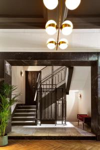 a lobby with a staircase with a wrought iron gate at Radisson Blu Hotel, Madrid Prado in Madrid