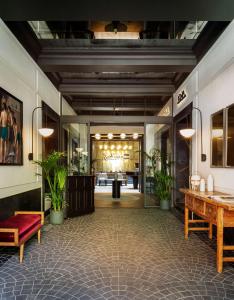 a lobby with tables and potted plants in a building at Radisson Blu Hotel, Madrid Prado in Madrid