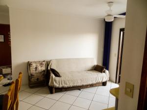 un salon avec un canapé et un ventilateur de plafond dans l'établissement Apartamento Condomínio Mediterranée, à Capão da Canoa