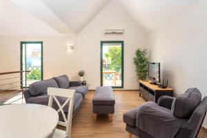 uma sala de estar com sofás e uma televisão de ecrã plano em Holiday house in elite residential area of Faro em Faro