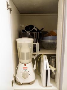 un mixeur blanc installé à l'intérieur d'une armoire dans l'établissement Apartamento Condomínio Mediterranée, à Capão da Canoa