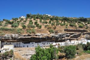 a group of white buildings on a hill at Casa entre Rocas Setenil in Setenil