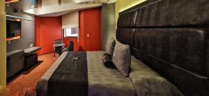 a bedroom with a large bed with a large headboard at Hotel Lua in Mexico City