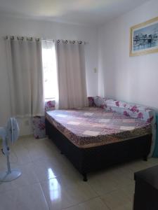 ein Schlafzimmer mit einem Bett in einem Zimmer mit einem Fenster in der Unterkunft Casa com piscina in Araruama
