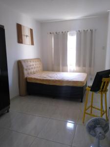 Casa com piscina في أرارواما: غرفة نوم بسرير وكرسي ونافذة