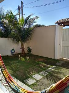 a hammock in front of a house with a palm tree at Casa com piscina in Araruama