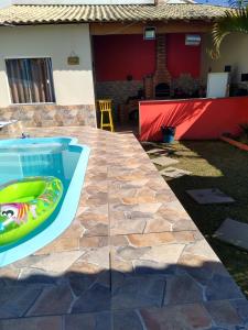a backyard with a swimming pool and a house at Casa com piscina in Araruama