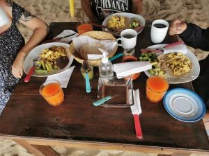 una mesa de madera con platos de comida. en La Máxima & LGBT en Zipolite