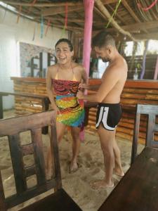 un hombre y una mujer de pie en la arena en La Máxima & LGBT en Zipolite
