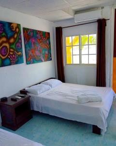 a bedroom with two beds and a window at Hotel Cocotal in Isla Grande
