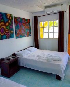 Un dormitorio con dos camas y una ventana. en Hotel Cocotal, en Isla Grande