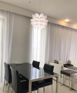 a dining room with a table and chairs and a chandelier at Ocean Star Condominium in Seogwipo