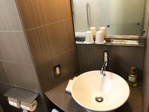 a bathroom with a white sink and a mirror at Citadines Central Shinjuku Tokyo in Tokyo