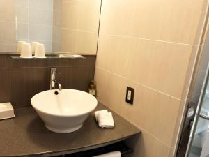a bathroom with a white sink on a counter at Citadines Central Shinjuku Tokyo in Tokyo