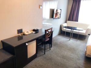 a hotel room with a desk and a table at Citadines Central Shinjuku Tokyo in Tokyo