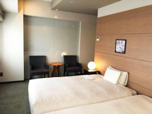 a hotel room with a bed and two chairs at Citadines Central Shinjuku Tokyo in Tokyo