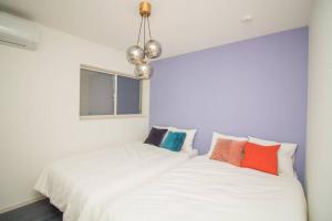 a bedroom with two beds with colorful pillows at Ultra Stay in Osaka