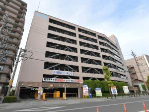 a large building with a parking lot in front of it at APA Hotel Ogaki Ekimae in Ogaki