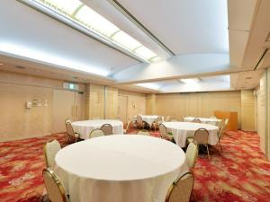 una sala de conferencias con mesas y sillas blancas en APA Hotel Ogaki Ekimae, en Ōgaki