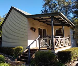 uma pequena casa com um alpendre com um deque em The Paddocks em Maleny